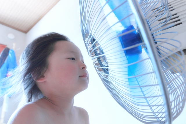 扇風機の風を冷たくするグッズ　小さい子供が扇風機の前で涼しそうにしている画像